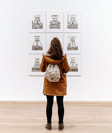 Photo of a woman looking at art in a gallery.